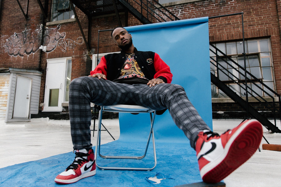 Vintage varsity-style jacket worn with plaid trousers and red high-top sneakers