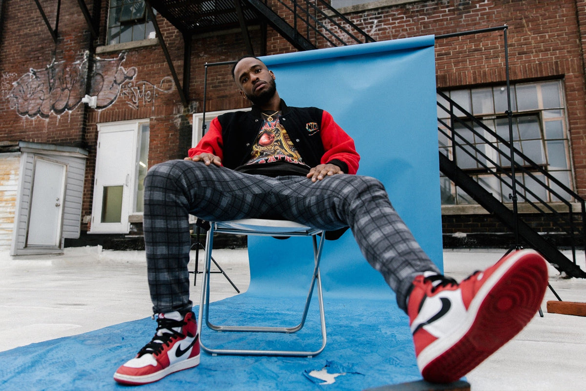 Vintage varsity-style jacket worn with plaid trousers and red high-top sneakers